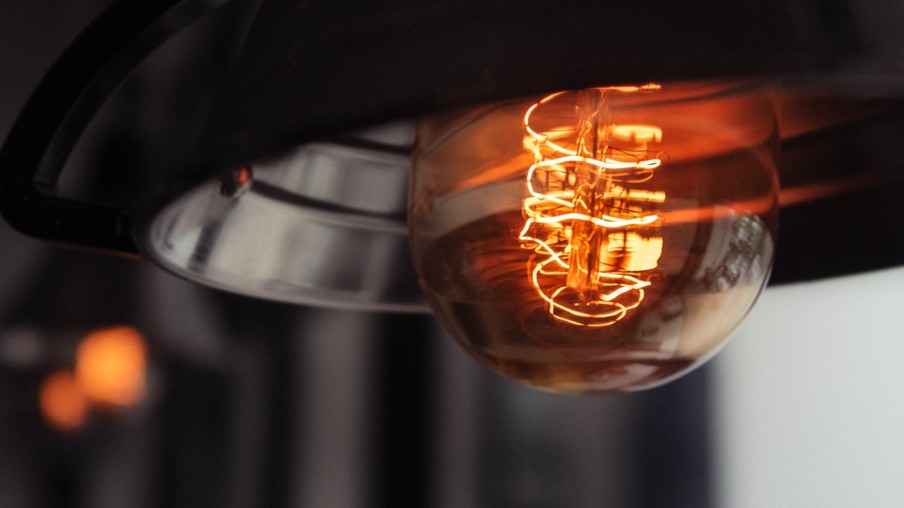 A closeup shot of a lit large lightbulb with a blurred background